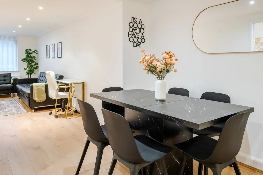 Dining table with a black marble top and the living room beyond