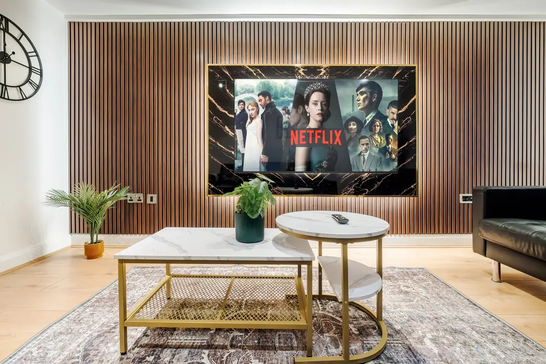 Marble and brass coffee tables in front of the TV wall