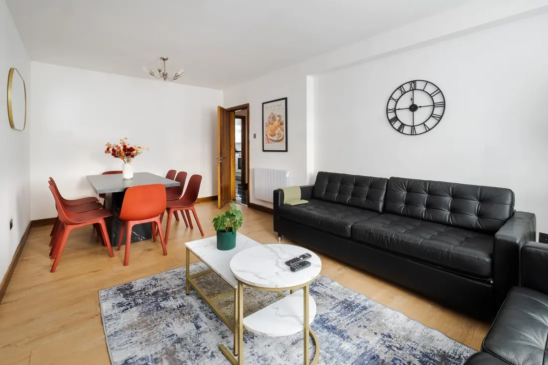 Sofas and dining table under the wall clock